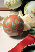 Load image into Gallery viewer, Close-up of hand-painted green leaves on the Winter Jasmine round ornament in Cinnamon
